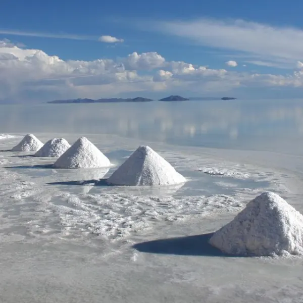 Pyramides de sel sur un marais salant, ciel et nuages à l’horizon